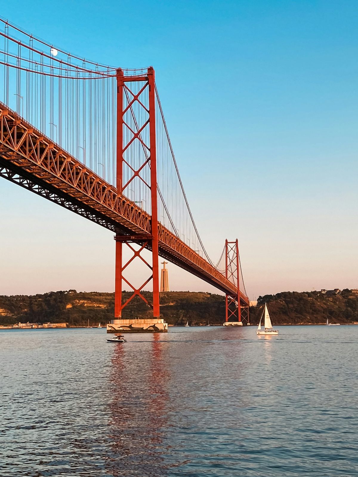 Sailing under the 25 de Abril bridge at sunset